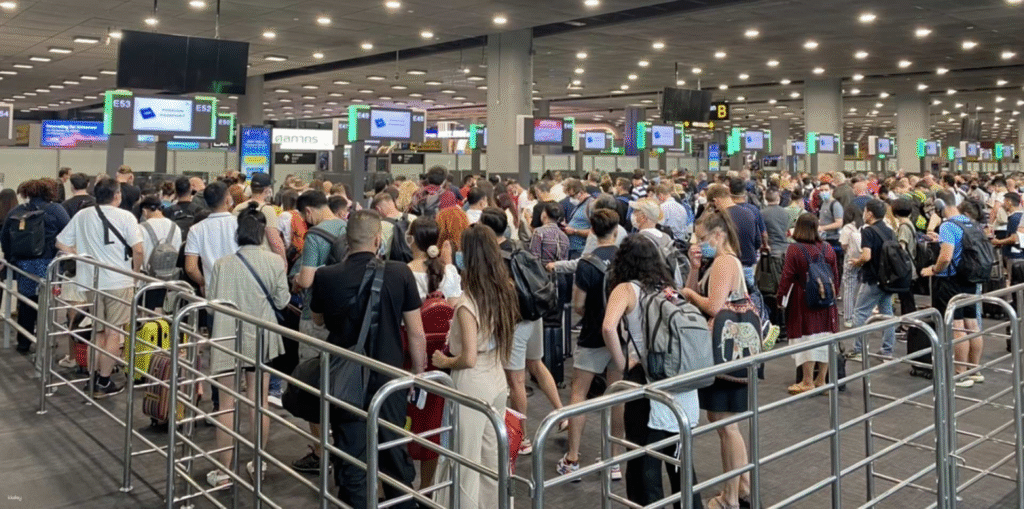 Busy arrivals area at Bangkok Suvarnabhumi Airport with travelers queuing