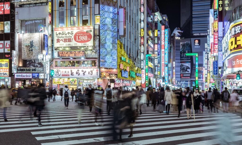 Solo traveler exploring Tokyo at night with eSIM connectivity