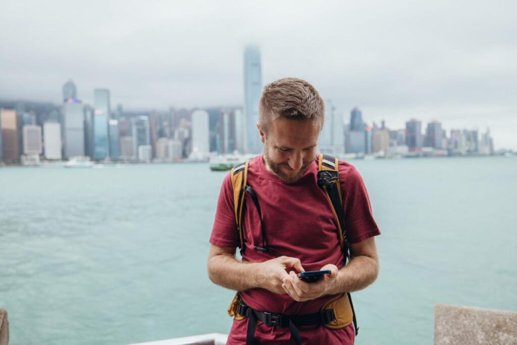 Business traveler using smartphone showing importance of business travel china hong kong esim connectivity